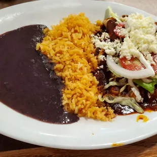 Lunch portion of red mole enchiladas w/black refried beans &amp; rice.