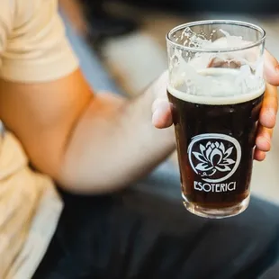 a man holding a pint of beer