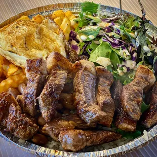 Gaucho (steak) plate over rice, fries, beans, &amp; salad.
