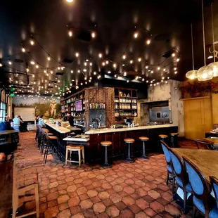 a restaurant with a brick floor and a bar