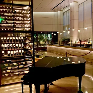 Jean George's interior dining with a wine showcase and grand piano