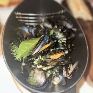 a bowl of mussels in a saucer