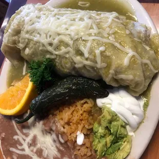 Wet burrito asada in green sauce with beans and rice.