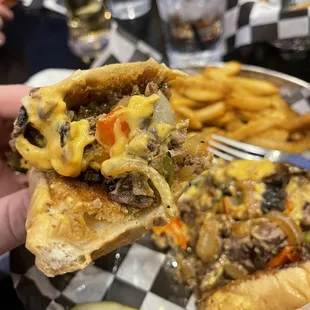 a hand holding a half eaten sandwich