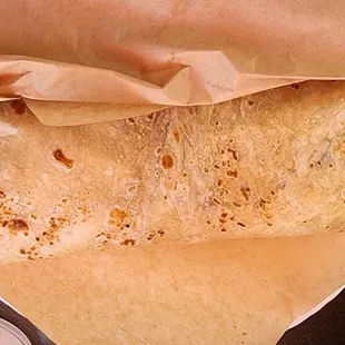 a burrito wrapped in brown paper