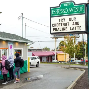 three people standing outside of a restaurant