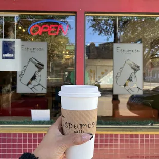 a hand holding a cup of coffee