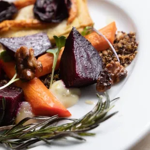 Roasted tricolor carrot and beet salad with a quinoa / sunflower seed crunch, apple jelly, chives emulsion, candied walnuts, and micro green