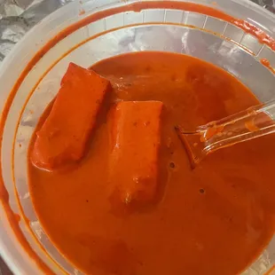 a bowl of tomato soup with a whisk in it
