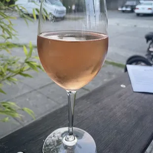 a glass of wine sitting on a table