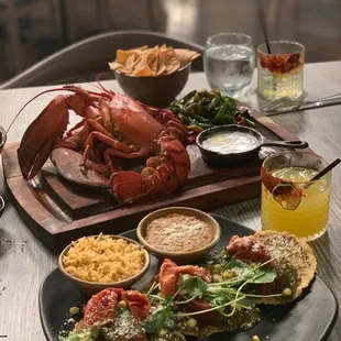 a lobster, chips, and a salad on a table