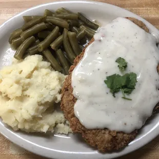 Homemade chicken fried steak served with potatoes and green beans!