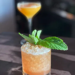 a closeup of a cocktail with a mint leaf garnish