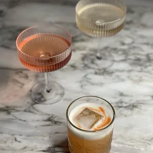 three cocktails on a marble table