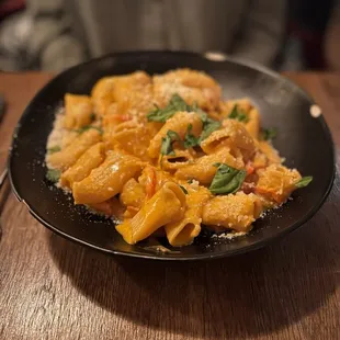 a plate of pasta on a wooden table
