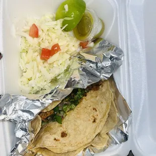 2 tacos with complimentary cabbage and diced tomatoes toppings
