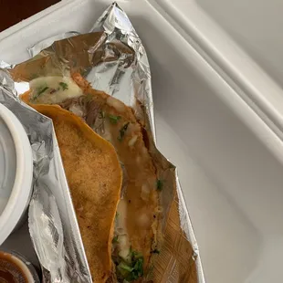 a taco and sauce on a tray