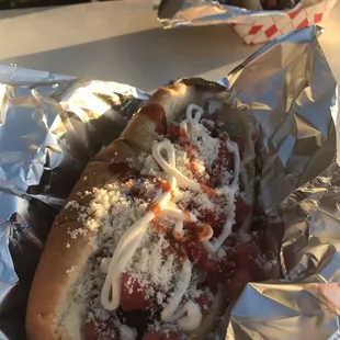 Bacon wrapped hot dog with grilled onions grilled jalapeños fresh diced tomatos cream and tapatio
