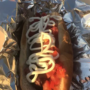 Bacon wrapped hot dog with fresh diced tomatos and cremated