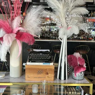 Antique typewriter, three decorative pieces sitting on top of a bookshelf.