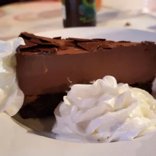 a slice of chocolate cheesecake with whipped cream