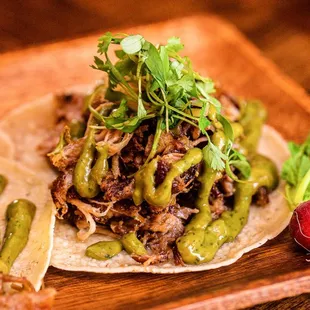 two tacos on a wooden tray
