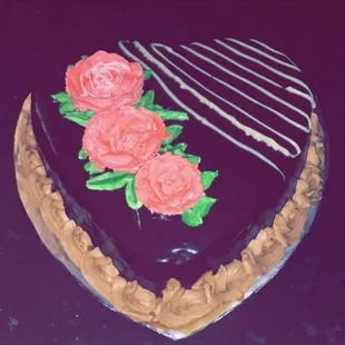 a heart shaped chocolate cake decorated with roses