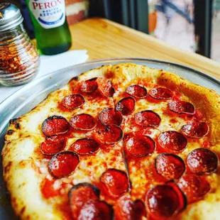 a pepperoni pizza on a pan