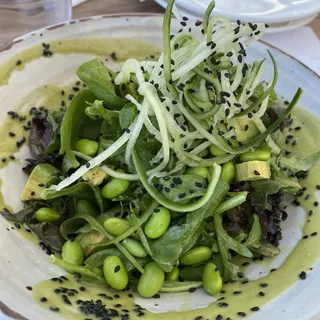 Big green salad bowl with avocado and garlic dressing