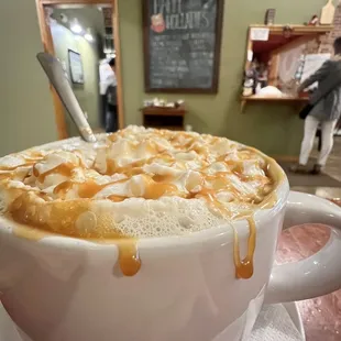 A mug of house blend caramello coffee topped with whipped cream.  hannahjacole