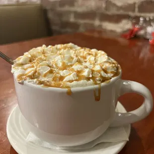 A mug of house blend caramello coffee topped with whipped cream.  hannahjacole