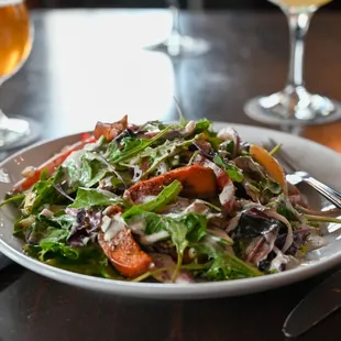 a plate of salad and a glass of beer