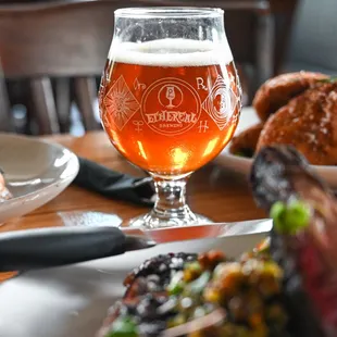 a glass of beer and plates of food