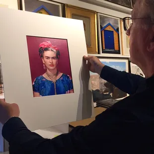 Owner, Terry Etherton inspecting a Nickolas Muray image of Frida Kahlo.