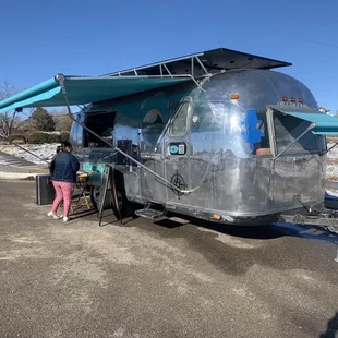 a woman standing in front of an airstream