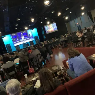 Seating in between coffee shop and book store with a screen to watch sermon going on in another nearby building.