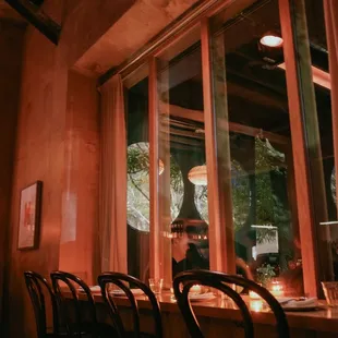 a row of bar stools in front of a window