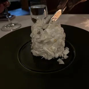 a person cutting a cake with a knife