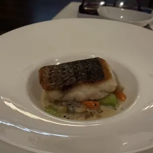 a white plate with a fish dish on it