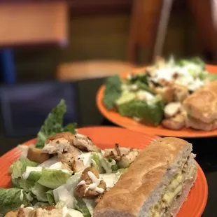 two plates of salad and a sandwich