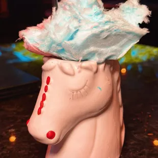 a unicorn cup with a feather on top