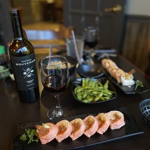 a plate of sushi and a glass of wine