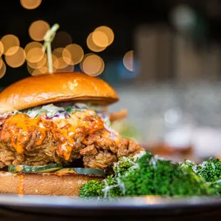 a fried chicken sandwich with a side of broccoli
