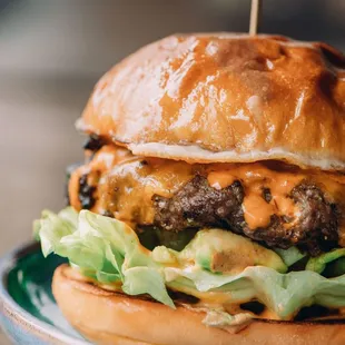 a cheeseburger with lettuce on a plate