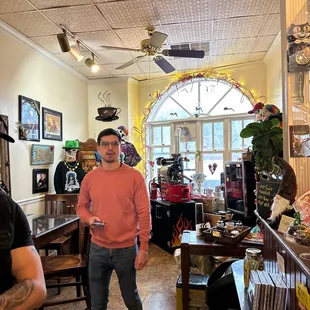 a man in a pink sweater standing in a restaurant