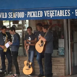 a group of men playing music outside of a store