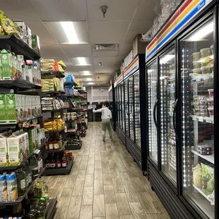 a grocery store aisle with refridgerators