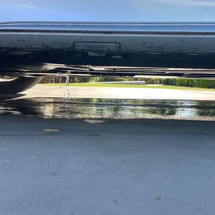 Water pouring out under the car