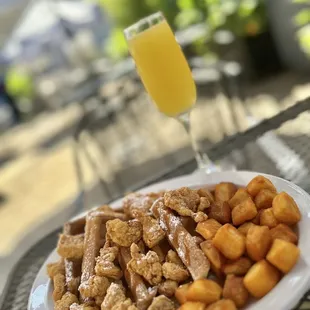 a plate of food and a glass of orange juice