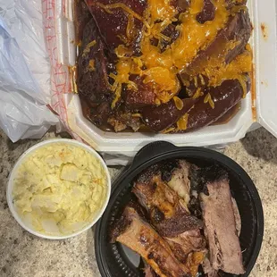 In the white container (FULLY LOADED POTATO), potato salad, and ribs and brisket